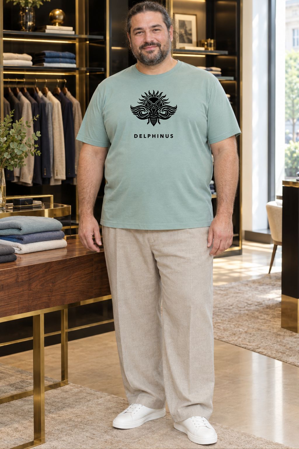 LE PROVENÇAL CURVE – homme curve portant le tee-shirt unisexe vert sauge au logo noir avec un pantalon stone, boutique élégante noir et or, DELPHINUS

