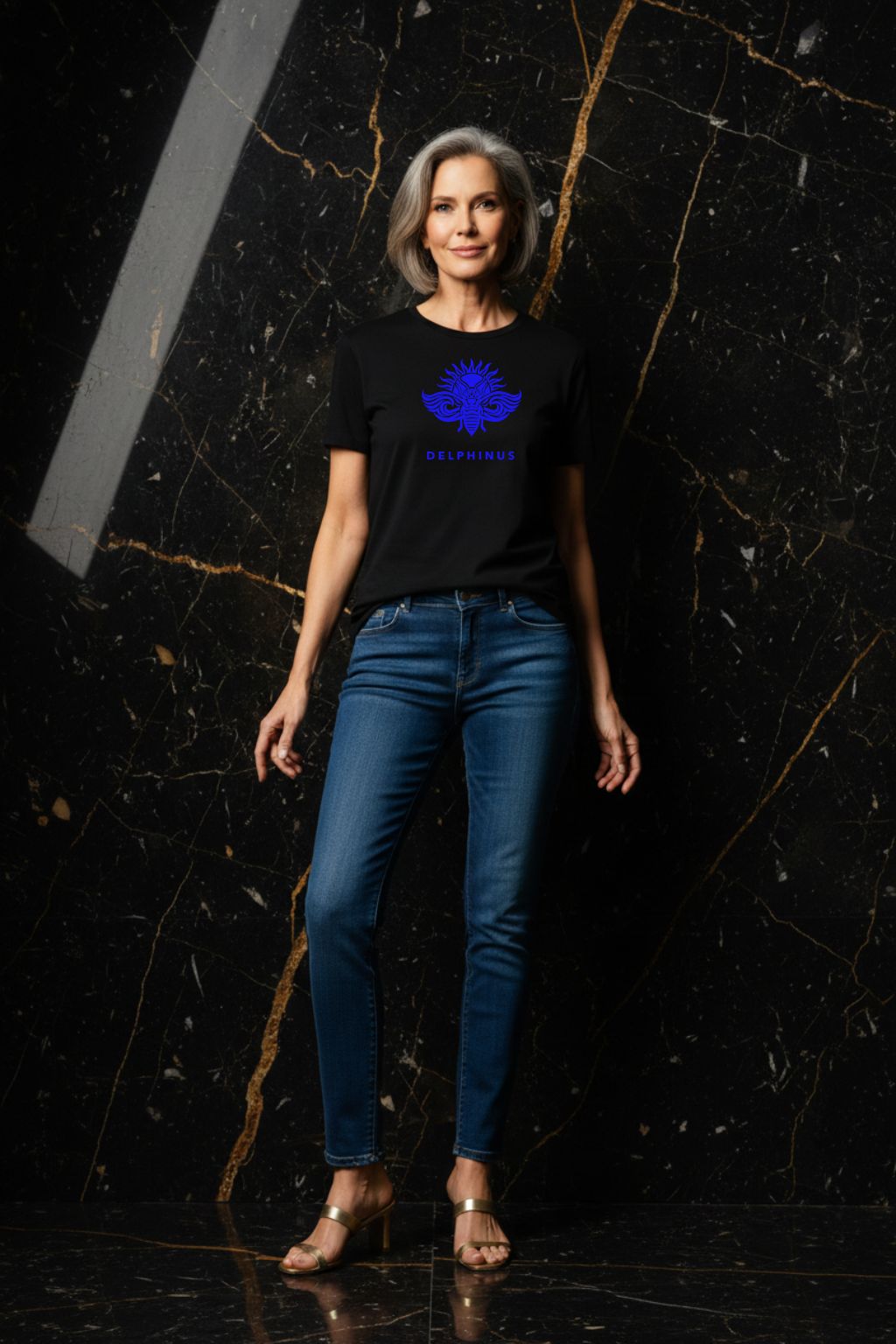 LA LIBERTÉ – T-shirt unisexe noir logo bleu DELPHINUS, femme mature et raffinée, ambiance premium marbre noir et or, jean slim et sandales dorées, DELPHINUS