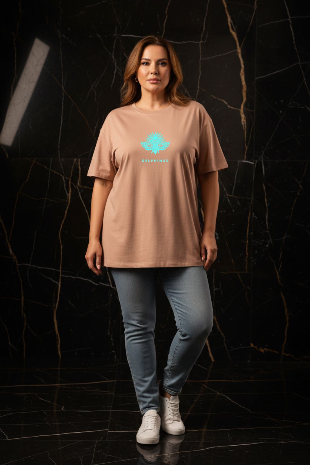 L'ÉVASION CURVE – T-shirt unisexe nude beige logo turquoise DELPHINUS, femme curve confiante, ambiance premium marbre noir et or, jean slim et sneakers blanches, DELPHINUS