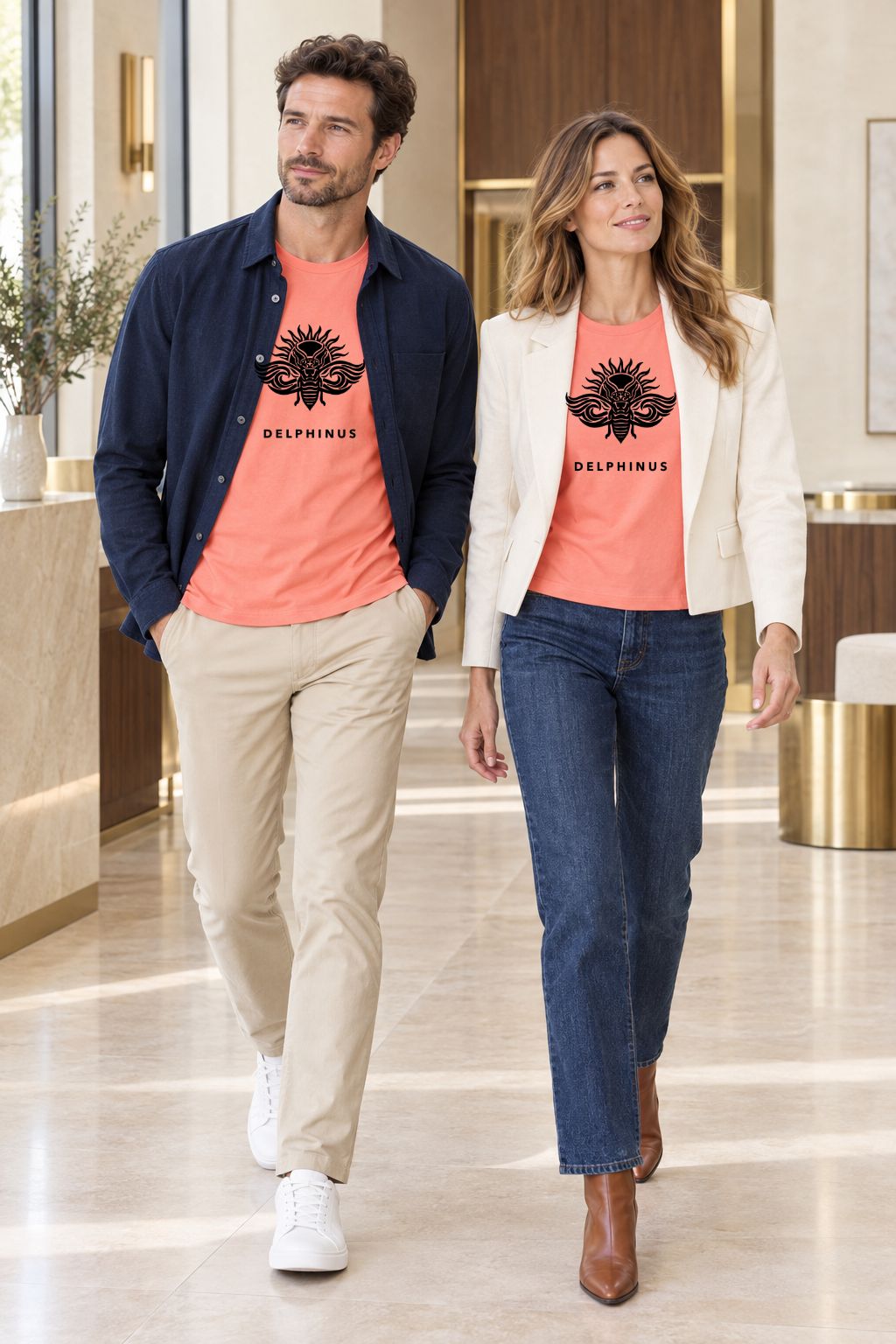 LE SOLAIRE – couple portant le tee-shirt unisexe Corail au logo Noir Nuit, hall contemporain lumineux, DELPHINUS