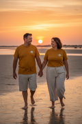 LE JUILLETISTE Sun Yellow CURVE – T-shirt unisexe jaune doré logo cigale blanc, couple curve élégant marchant main dans la main sur la plage de Camargue au coucher de soleil, DELPHINUS