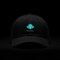 La Divine – Casquette noire logo turquoise DELPHINUS brodé, posée sur marbre noir veiné or, éclairage dramatique doré, reflet visible