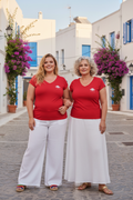 LE CARACTÈRE CURVE – Duo femmes très curve 20 et 50 ans en t-shirts rouges col V logo cigale blanc, village méditerranéen fleuri, DELPHINUS