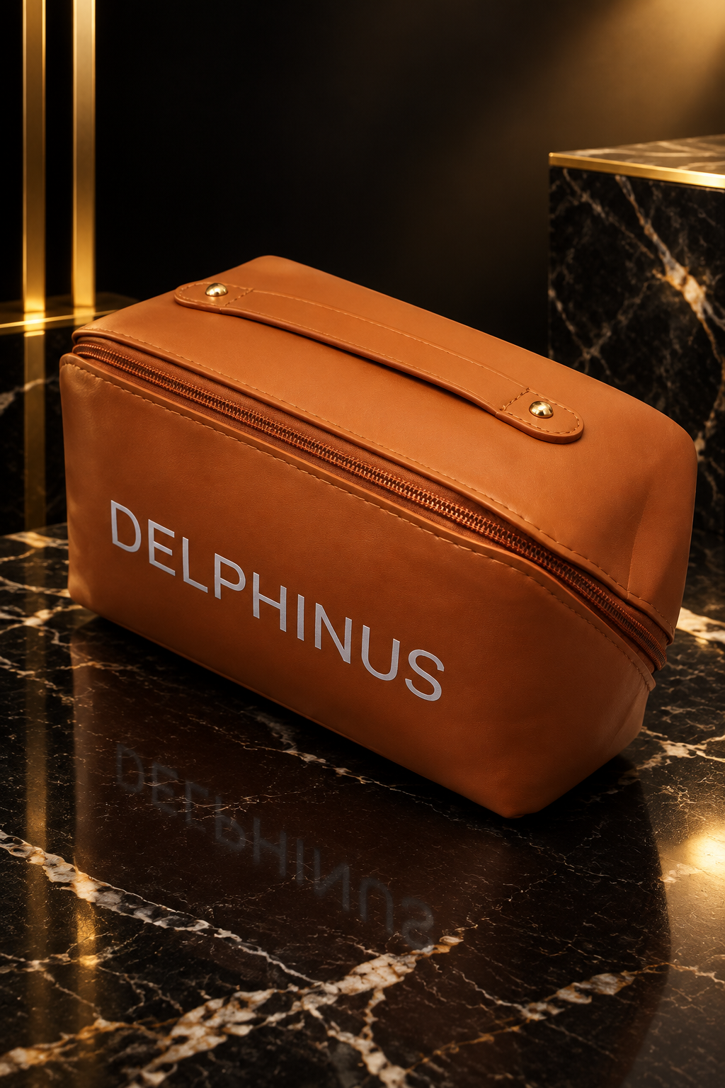  L'ICONIQUE – trousse en similicuir marron cognac vue de trois-quarts sur marbre noir, DELPHINUS